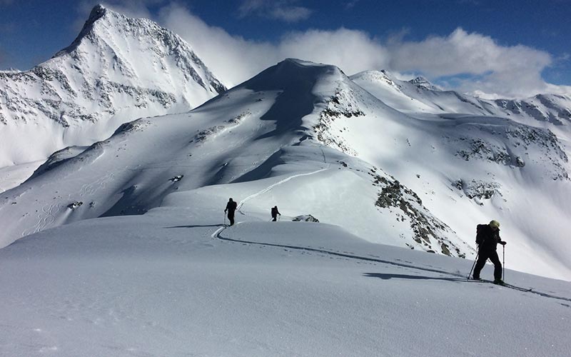 Backcountry hikers walking on snowy mountains near Mallard Mountain Lodge.