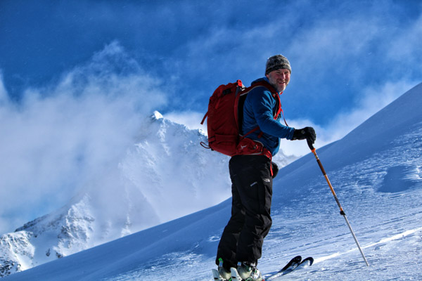 Smiling man ski touring at the Mallard Mountain Lodge in BC, Canada