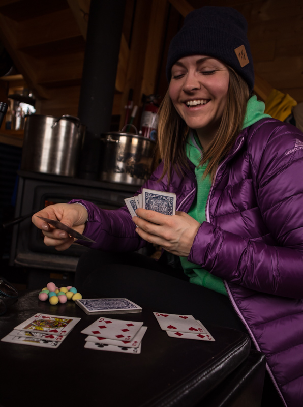 Woman playing cards in front of the fire at the Mallard Mountain Lodge