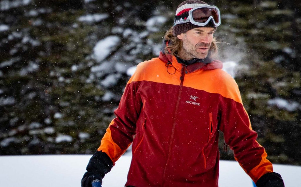 Upper body shot of man standing in ski touring clothing layers 