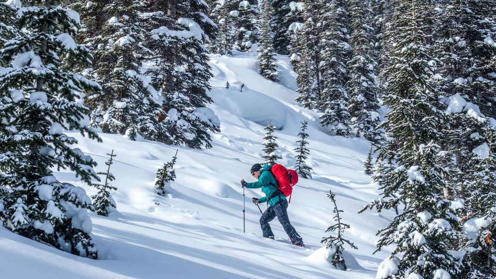 person ski touring uphill at mallard mountain lodge