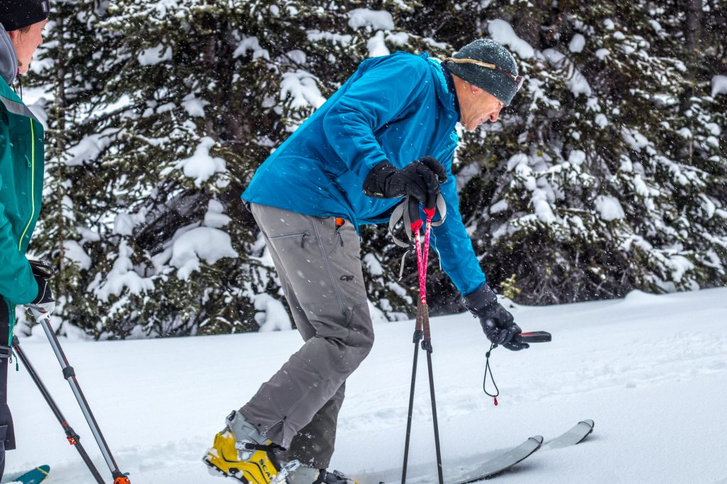 Ski guide testing transceiver in the backcountry 