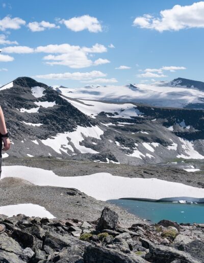 hiker above alpine lake in summer