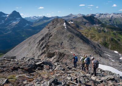 group of hikers descending alpine ridge