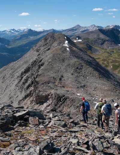 group of hikers descending alpine ridge